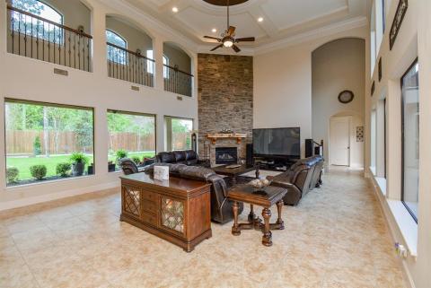 Formal living room has endless windows and a beautiful two-story stone fireplace