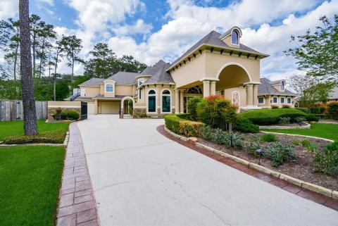 Left side of the driveway leads to a 4 car garage that is gated and also circles around to the front door and the porte-cochere