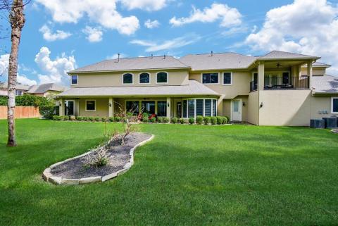 View of the rear of the home. Lots of windows! Roof was replaced in 2021. Access to this balcony is located in the game room/flex space.