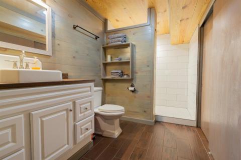 West side Master Bathroom continuing with tiled floors and shiplap walls. Closet to the right.