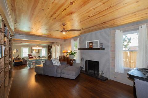 View from Living Area looking toward the Dining and Den. Notice all of the windows for natural lighting and the gorgeous ceilings and lighting bouncing off of the original refinished hardwood floors.