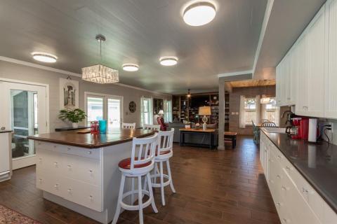 View from the kitchen to the Den. Fantastic tiled flooring that looks like hand-scraped wood flooring enhanced by the abundance of lighting.