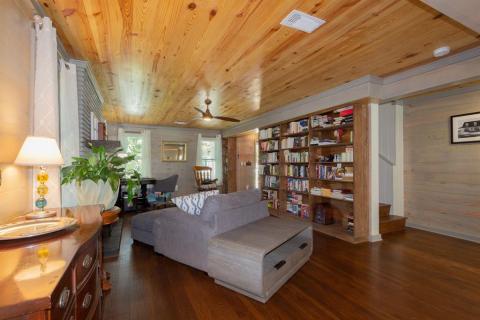 View of the Living Area looking toward the entry, and to the right the staircase leading to the upstairs three bedrooms and two bathrooms.  Also, another look at the one-of-a-kind bookcases.