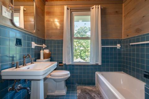 Upstairs Bathroom maintaining original period tile with refinished tub and accommodates two bedrooms.