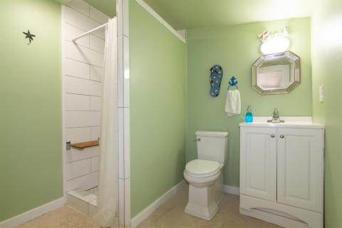 Bathroom off the screened-in porch with a shower and a teak shower seat. Easy to freshen up off after a swim in the amazing pool. Pool deck flooring for easy cleaning.