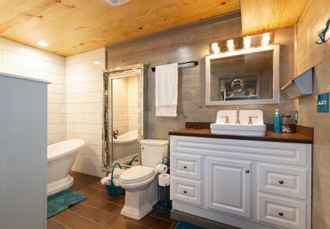 One of two spacious Master Bathrooms maintaining an original sink on a large vanity with plenty of storage.