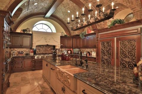 Another view of this magnificent kitchen! Gorgeous granite, built in custom refrigerator/freezer with decorative doors, custom cabinetry, ornate custom vent hood, stainless steel appliances, impressive intricate tin backsplash, & tons of counter space to prepare meals. Another view of this magnificent kitchen! Gorgeous granite, built in custom refrigerator/freezer with decorative doors, custom cabinetry, ornate custom vent hood, stainless steel appliances, impressive intricate tin backsplash, & tons of counter space to prepare meals.