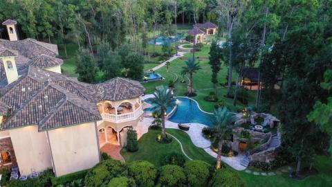 Aerial picture that shows just part of the extraordinary back yard of this Luxurious Estate. One of three pools, the main pool is two-tiered with a swim up bar and TV in a cave, as well as a fire pit with seating area above the cave. Aerial picture that shows just part of the extraordinary back yard of this Luxurious Estate. One of three pools, the main pool is two-tiered with a swim up bar and TV in a cave, as well as a fire pit with seating area above the cave.