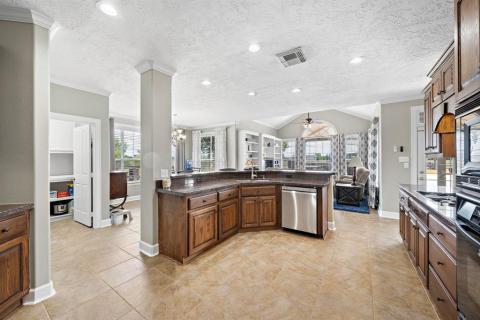 A view from the other entry way into this delightful kitchen with a peek of the Laundry room, Family room, and Breakfast table area.