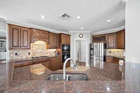 Another view of the kitchen from the Breakfast Bar.  Wine rack, stainless steel appliances, tile backsplash,granite counter tops, under counter lighting, and the list goes on!