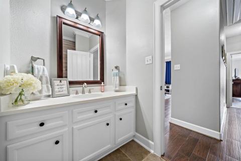 Look at the size of this Half bath, and this is only the front half of it; however, you are getting another sneak peek.... the hallway leading towards the Primary Bedroom