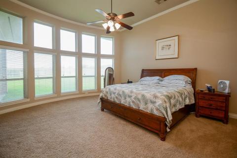 Your primary sanctuary is generously surrounded by floor-to-ceiling bay windows, in the rear of the home, with views of your huge back property.