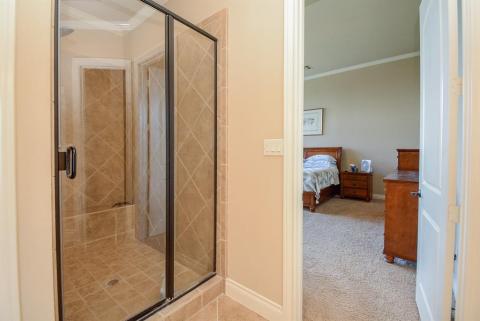This large glass enclosed shower is just footsteps from your bedside.