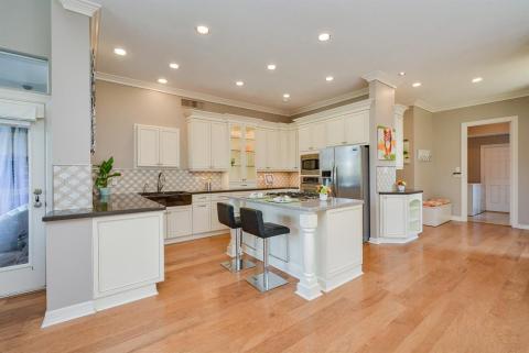 We'd expect nothing less than pristine perfection in the glorious chef/gourmet kitchen, with the inclusion of structural features supporting the sublime decor/architectural theme.The island offers decorative columns under the extended Microban countertop, with darker tones along wall counters and sophisticated, patterned backsplash. 42â€, soft close Kiva mid-century cabinetry with hand painted borders grace walls and floor, which is comprised of luscious, 6 1/2â€ wood planking.