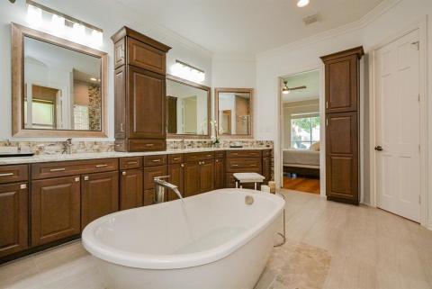 This is what deserved ultimate indulgence looks like without overdone opulence. Sand colored tiles nicely contrast with deep honey toned cabinetry/tower, light granite? Microban? countertops and artisan inspired tile backsplash.Gleaming, dual stainless steel sinks with Toto/Kraus faucets are within fingertip reach of abundant cabinetry and storage. Framed wall mirrors contribute to the magical glow of this unequalled space, just footsteps from your bedside.