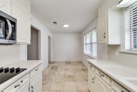Kitchen to Light Bright Breakfast Area with Travertine Tile