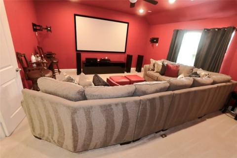 Welcome to a luxurious media room that combines entertainment and convenience with the addition of a well-equipped kitchenette.