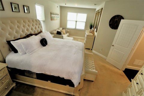 The master bedroom welcomes you with an atmosphere of refined tranquility and ample space. As you enter, your eyes are immediately drawn to the large sitting area that extends beyond the sleeping quarters, creating a separate oasis within the room.