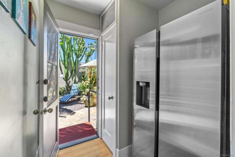 Area off kitchen for refrigerator and leading to garden