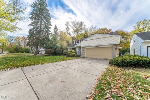 View of property exterior featuring attached garage and a lawn