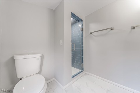Primary Ensuite Bathroom with walk in shower, toilet, and vaulted ceiling