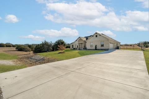 View of front of house featuring a garage and a front lawn