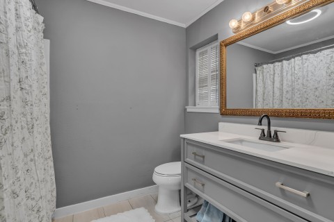 Updated primary bathroom with gorgeous vanity, updated plumbing fixtures, and shower-tub combo.