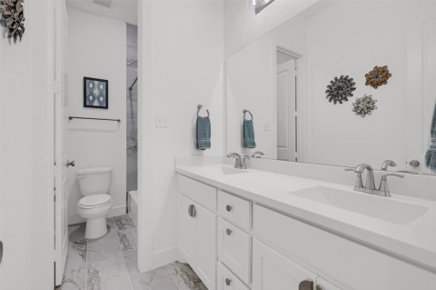 Full bathroom featuring shower / tub combination, vanity, and toilet