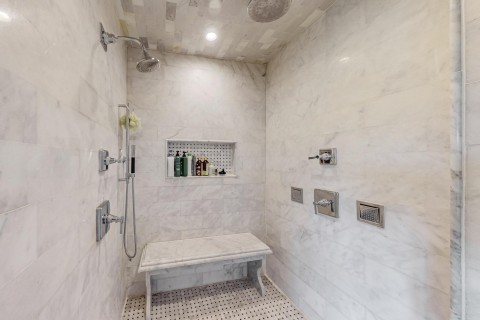 Primary bathroom Massive shower with 5 shower heads, marble bench and towel warmer