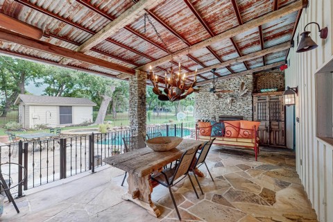 Huge covered patio flagstone flooring, reclaimed roof beams with metal roofing, stone masonry fireplace gas starter, builtin amoire and storage cabinets