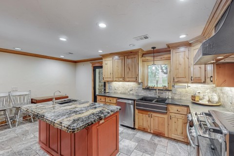 Kitchen boasts Knotty Alder cabinets, large granite island with vegetable sink