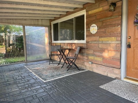 Sunroom featuring beam ceiling