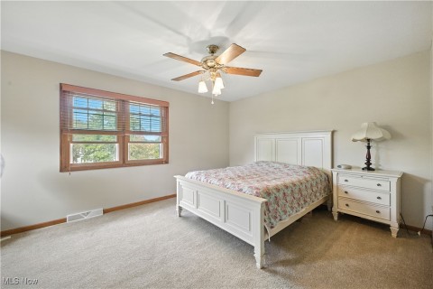 Carpeted bedroom with baseboards and a ceiling fan