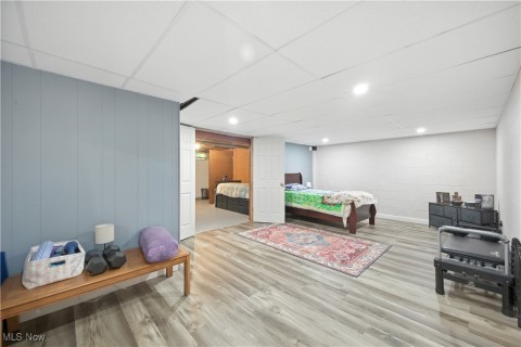 Bedroom with a drop ceiling, wood finished floors, and recessed lighting