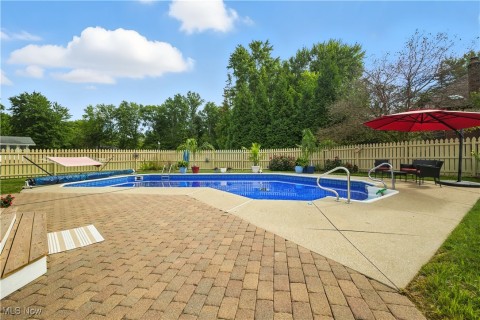 View of pool with a patio and a fenced backyard
