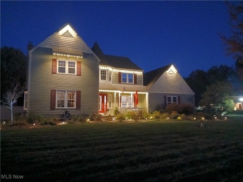 Victorian-style house with a porch and a lawn