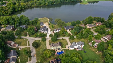 Aerial view of property and surrounding area with nearby suburban area and a large body of water