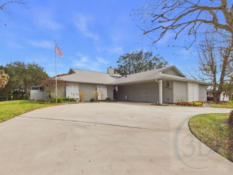 View of front of house featuring driveway, a garage, a chimney, a front yard, and roof with shingles