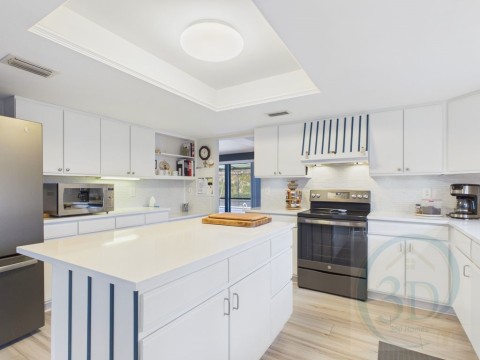 Kitchen with stainless steel appliances, white cabinetry, a raised ceiling, open shelves, and exhaust hood