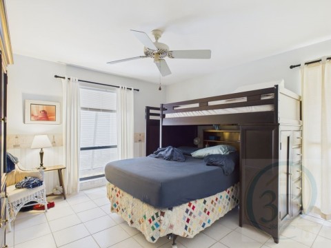 Bedroom with ceiling fan and light tile patterned floors