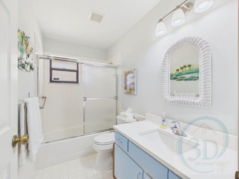 Bathroom with vanity and combined bath / shower with glass door
