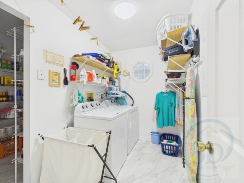 Laundry room with washing machine and dryer and light marble finish floors