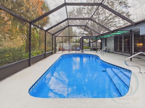Swimming pool featuring a lanai, a sunroom, and a patio