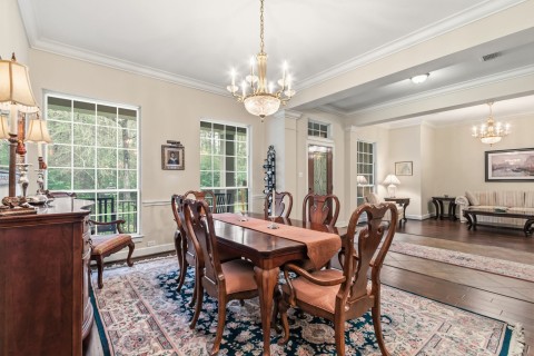 This well designed dining room features chair rail, crown molding, and engineered wood floors. Natural light streams in through two large windows. The chandelier is excluded from the sale.