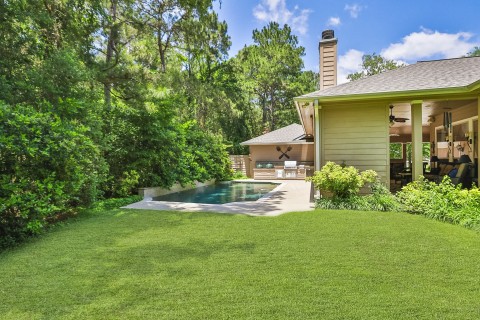 This backyard sanctuary boasts exquisite landscaping and a recently updated roof, complete with efficient gutters.