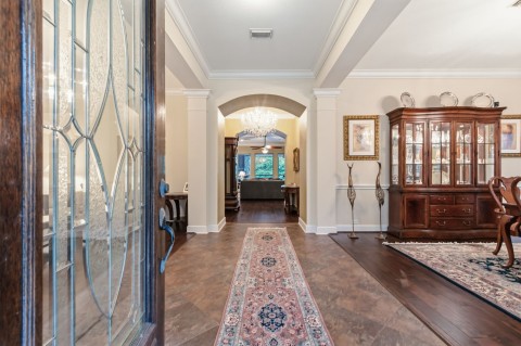 This elegant living space features hardwood flooring, tiled entryway with an arched passage. The lovely crown molding adds to the beauty of this house. The chandelier is excluded from the sale.