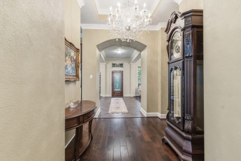A view towards the elegant foyer. The chandelier is excluded from the sale.