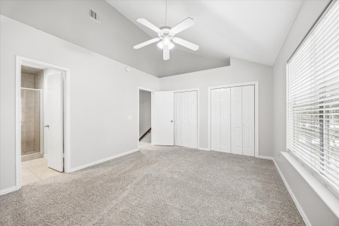 The primary bedroom boasts high ceiling washed in natural light with lots of closet space and recent carpet.