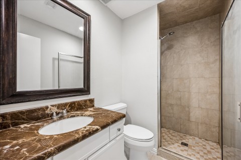 Primary bathroom with granite vanity and walk in shower.