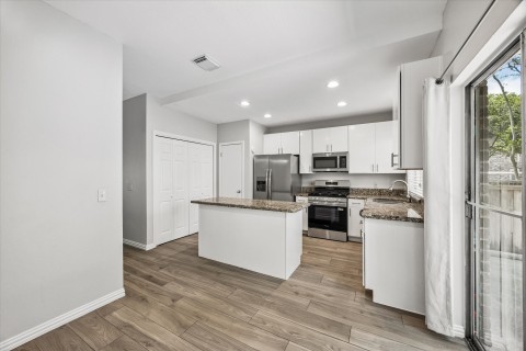 The kitchen is open plan with recently installed cabinets offering plenty of storage. Beautiful granite counters, large island, new gas range and stainless refrigerator..